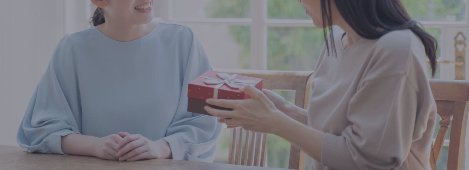 母にプレゼントを渡す娘の写真